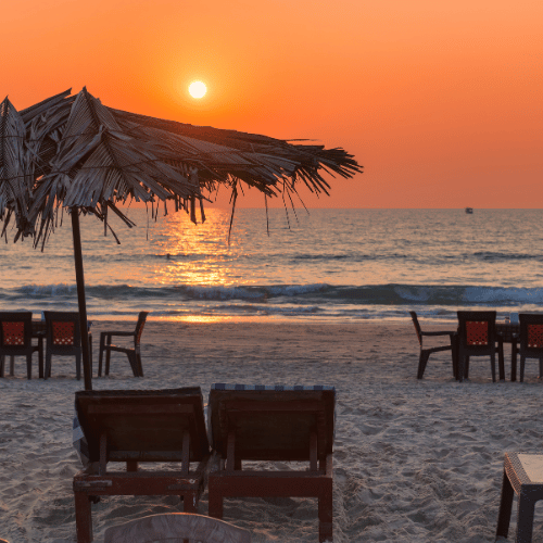 Goa beach sunset view with palm trees and boats – Goa tour package by NowShe Tours