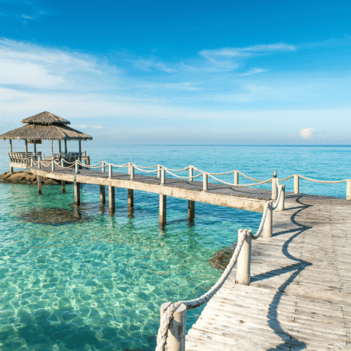 Thailand beach resort walkway over turquoise water – Thailand tour packages by NowShe Tours